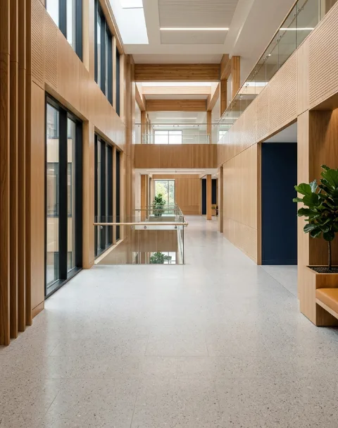 Bright public building corridor with timber panels and terrazzo floor